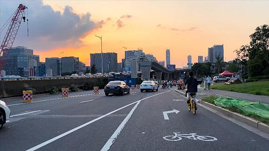 4K实拍上下班路上美女骑单车出行夕阳视频的预览图