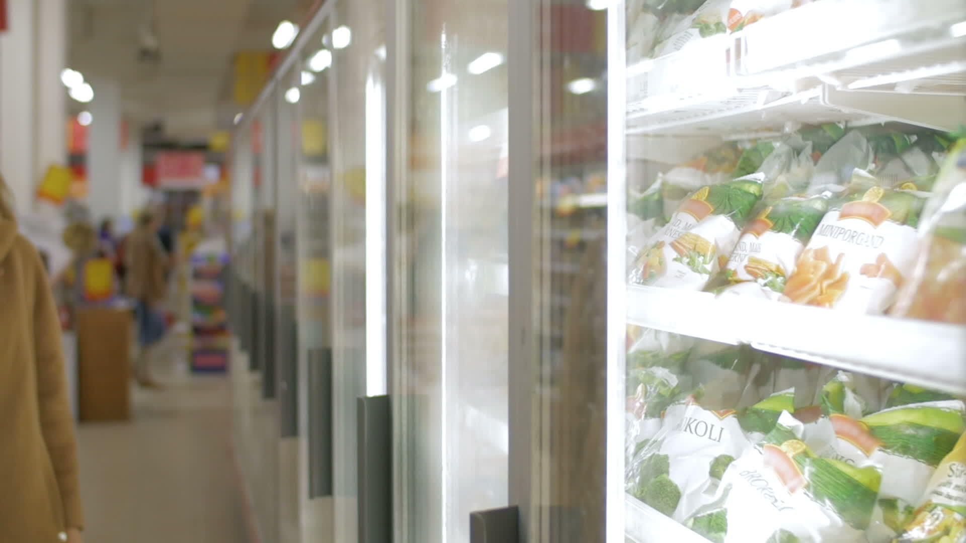 女人在商店的冰箱里吃冷冻产品视频的预览图
