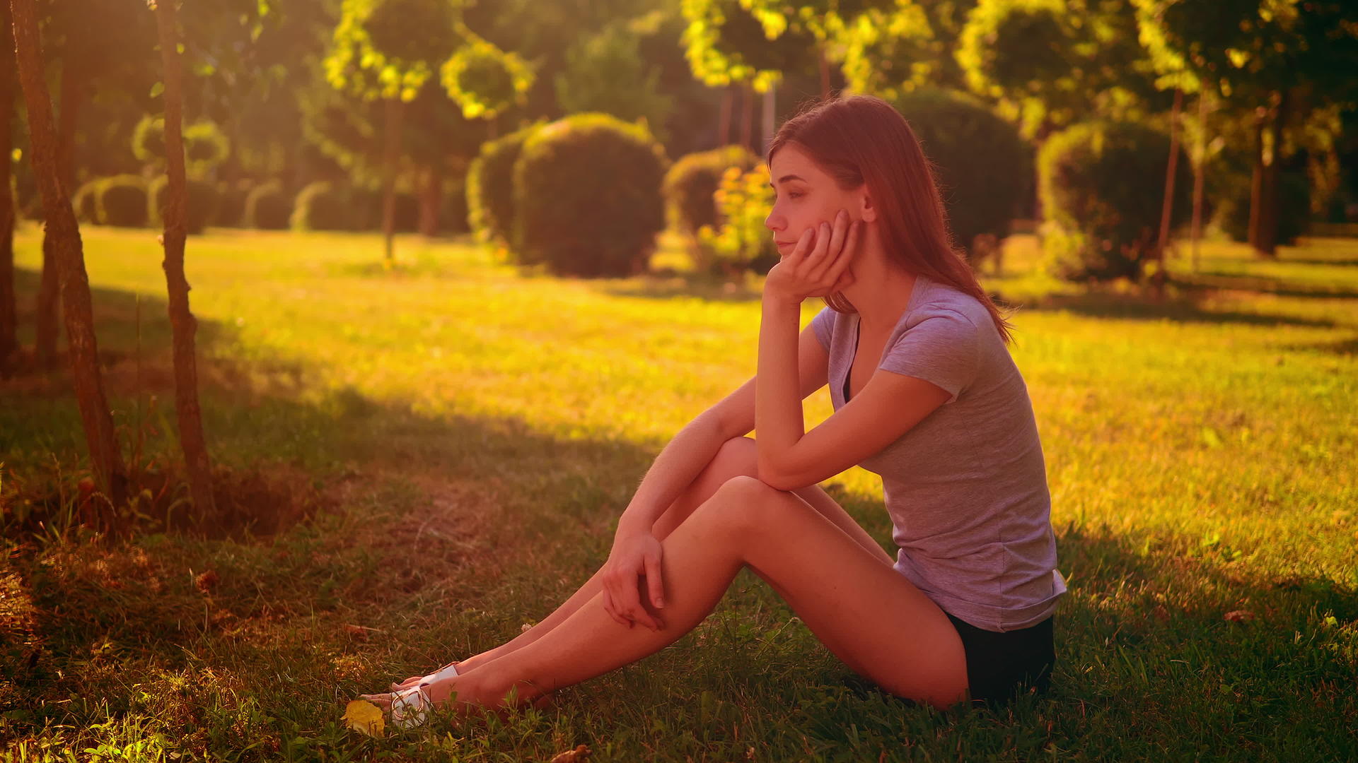 悲伤的女人坐在绿草上视频的预览图
