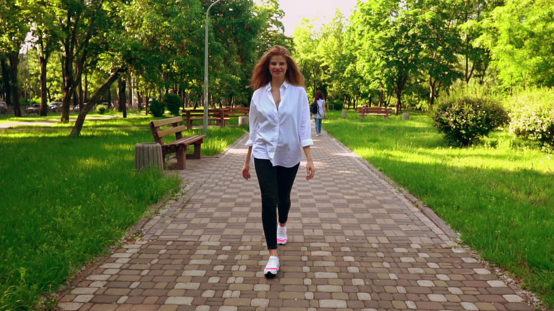 快乐的女人在公园里行走视频的预览图