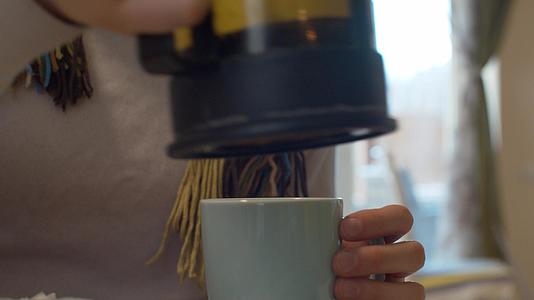 女人用手把茶倒进杯子里视频的预览图