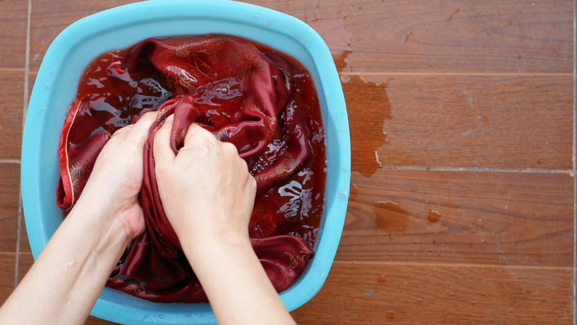 女人在盆里用手洗布红衬衫视频的预览图