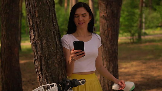 使用智能手机骑自行车的女孩视频的预览图