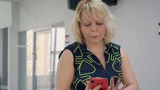 女性在健身训练中使用手机；在体操训练中视频的预览图