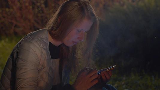 女性在森林中拥有智能手机视频的预览图