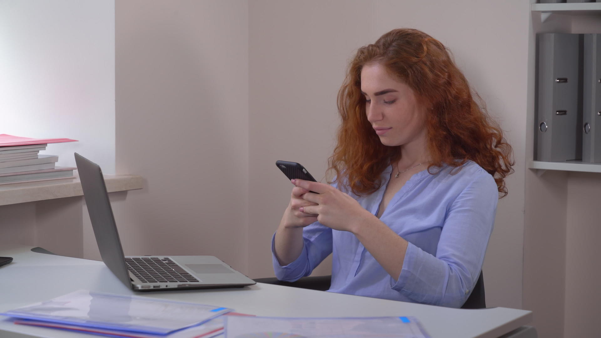 红发女性使用智能手机视频的预览图