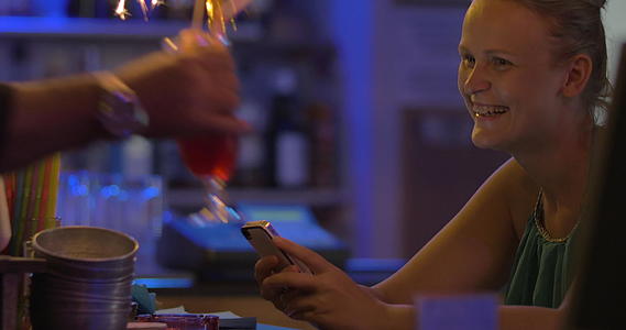 女性用智能手机订购鸡尾酒和火花视频的预览图