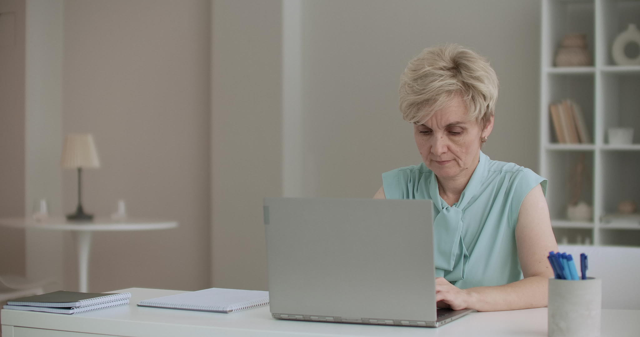 退休妇女在笔记本电脑上打字女作家在家工作和写作以便在家工作和写作视频的预览图