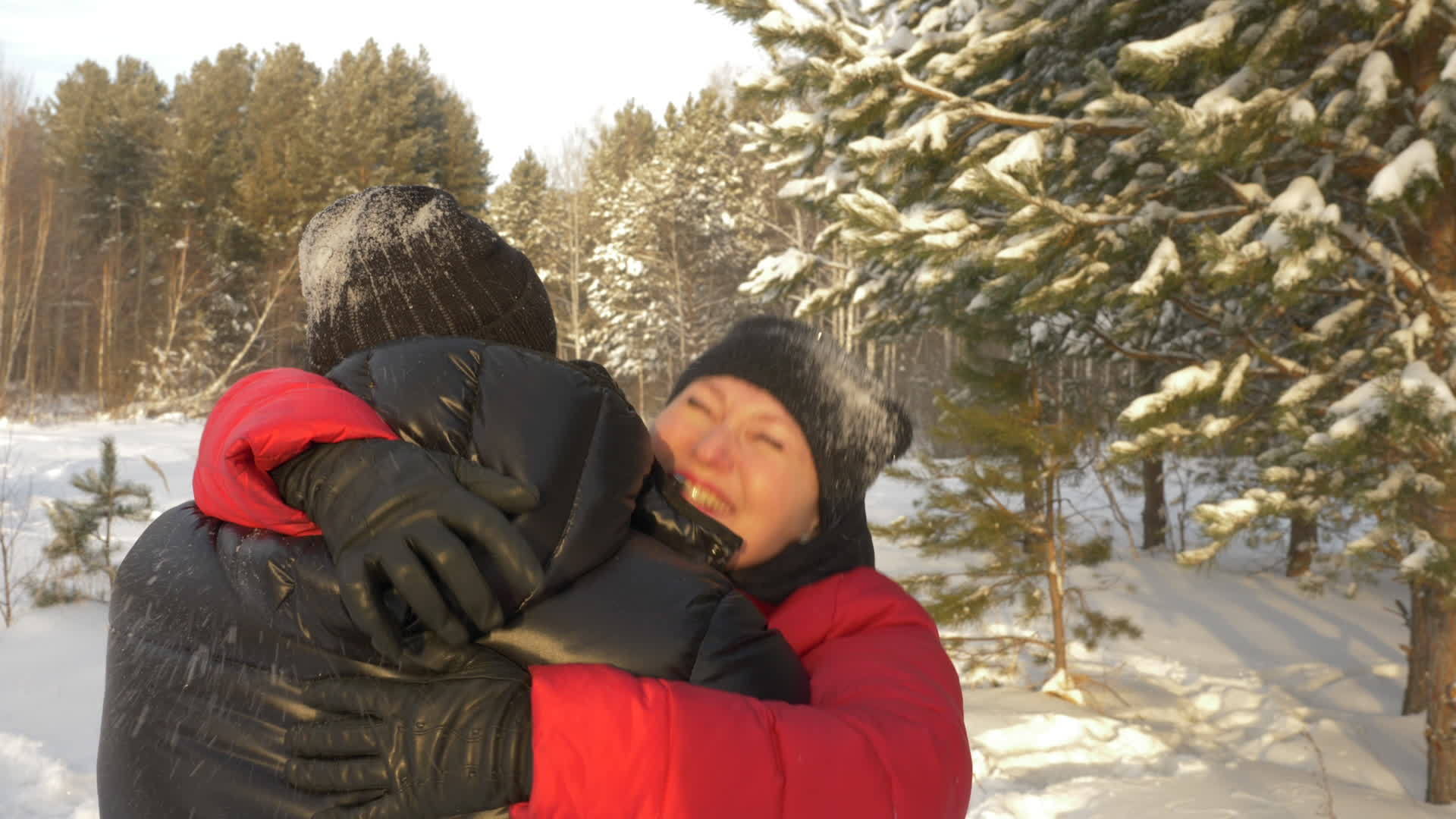 在雪地公园举行冬季聚会时女人微笑着拥抱和亲吻男人视频的预览图