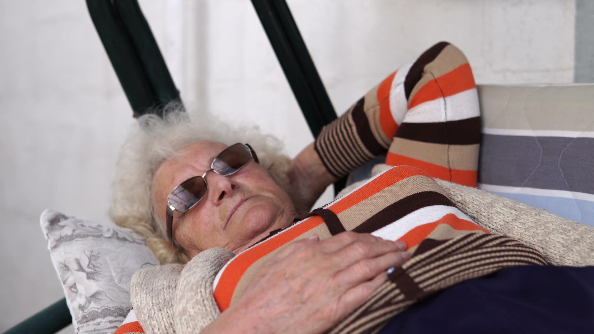 深思熟虑的老母亲在户外放松躺在秋千上视频的预览图