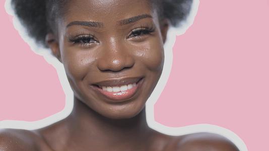 可爱的Afro女人们对着粉色背景的相机微笑视频的预览图