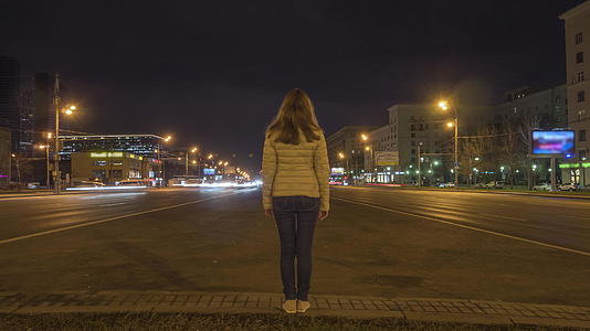 女人静静地站着晚上在高速公路上开车已经过去了视频的预览图