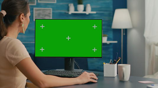 女性在看电脑时使用绿色屏幕模拟染色仪器按钮视频的预览图