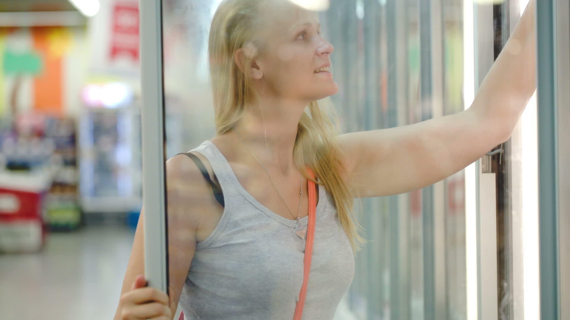 女人从店里的冰箱里提取产品视频的预览图