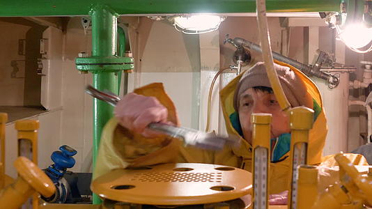 女机械师在浮船发动机舱工作时使用视频的预览图