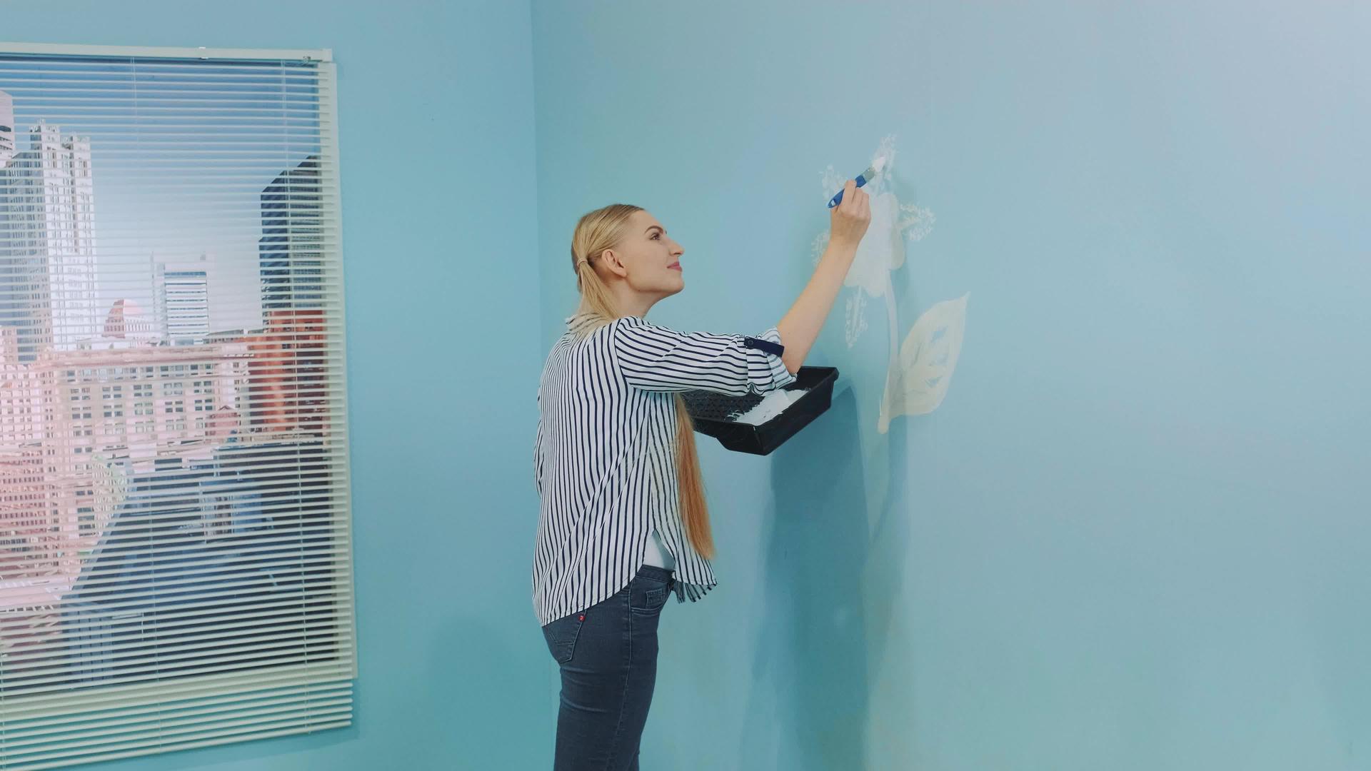 女性在墙上画花的面视频的预览图