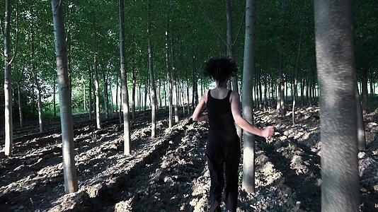 追逐一个害怕的女人在森林里奔跑的女孩试图逃离视频的预览图