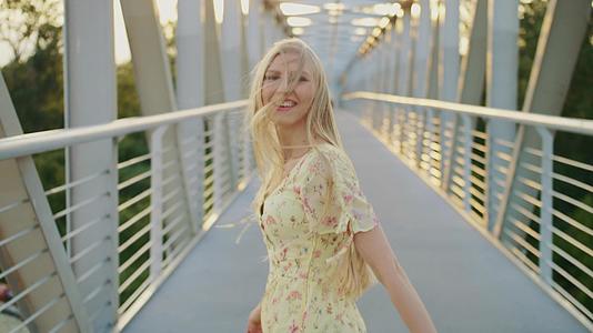 女人在桥上吐出头发金发女孩在人行天桥上奔跑吐出头发视频的预览图