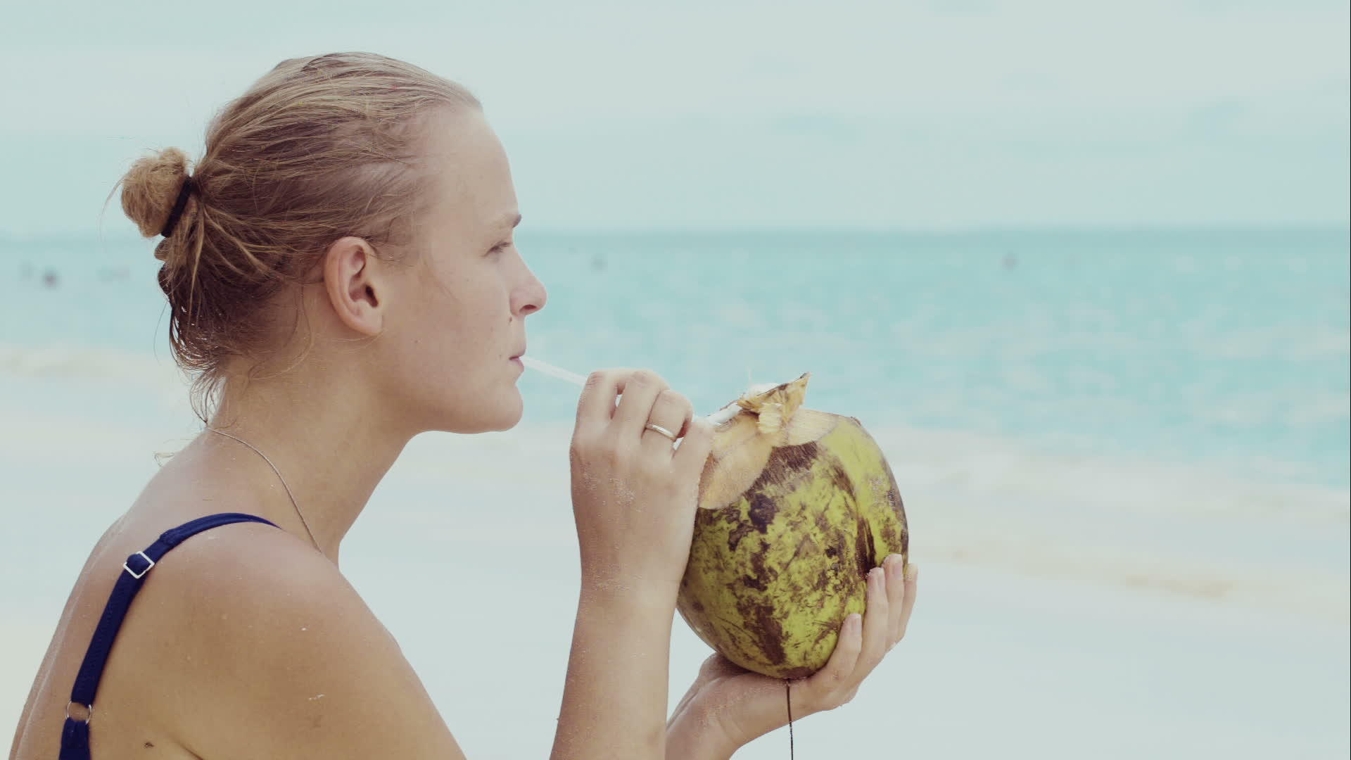 女人在海滩上喝椰子酒视频的预览图