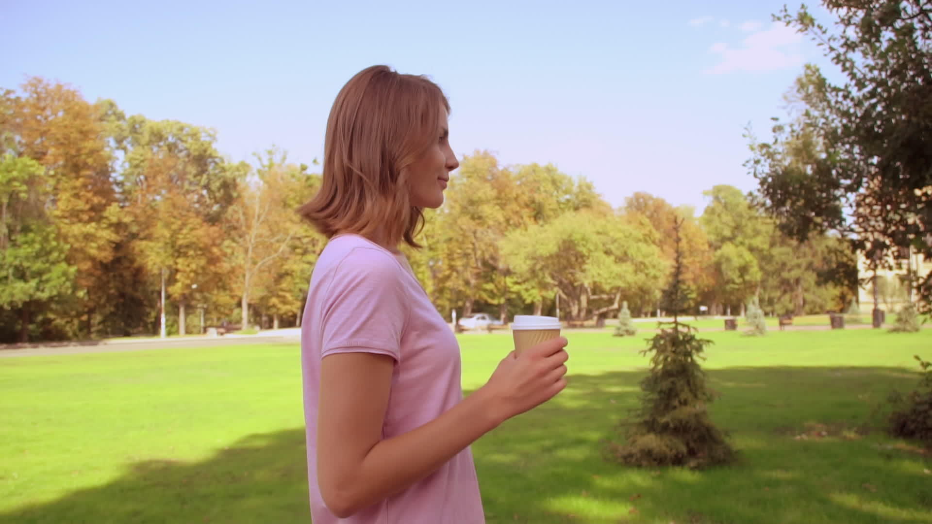 金发女人在公园喝咖啡视频的预览图