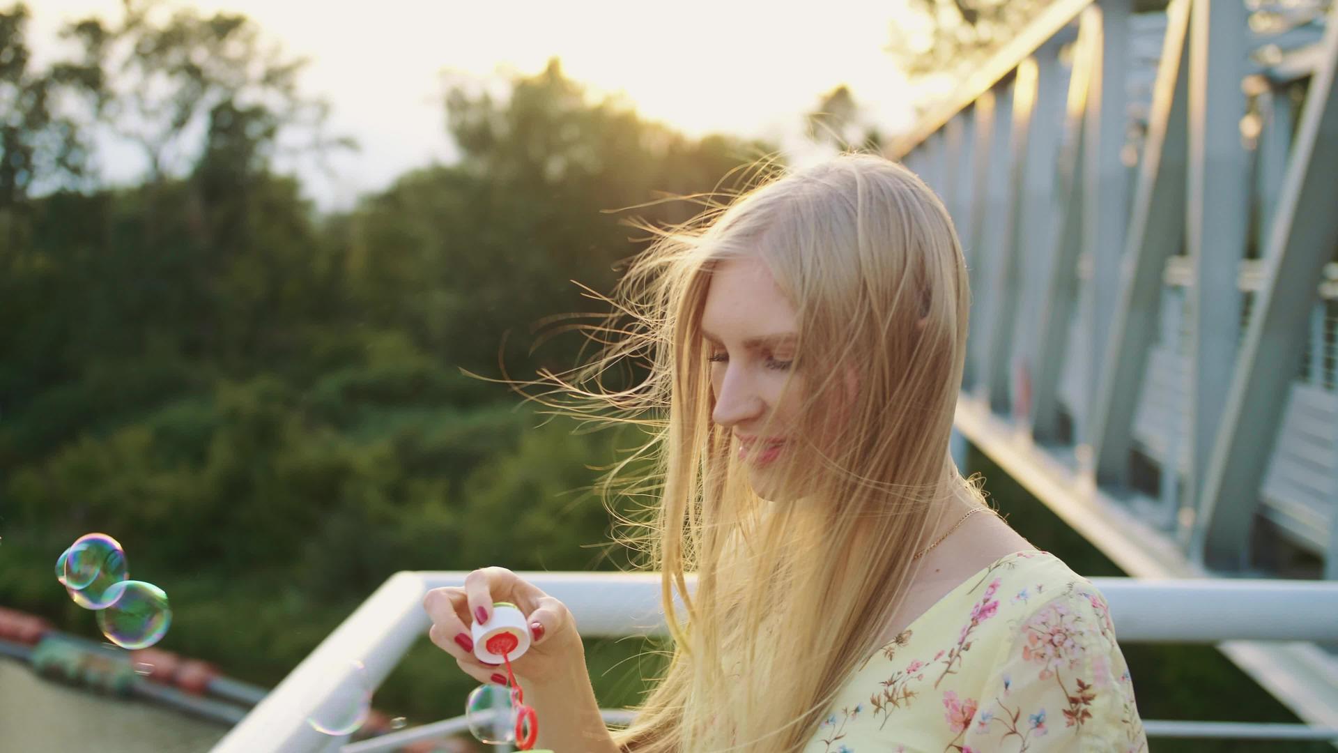 吹肥皂泡的女人美丽的年轻女人站在人行天桥上视频的预览图