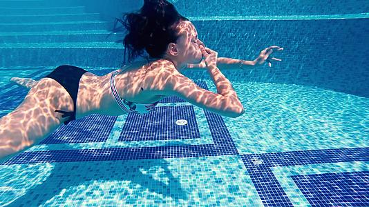 在豪华的游泳池中游泳时有吸引力的着鼻子慢慢地移动视频的预览图