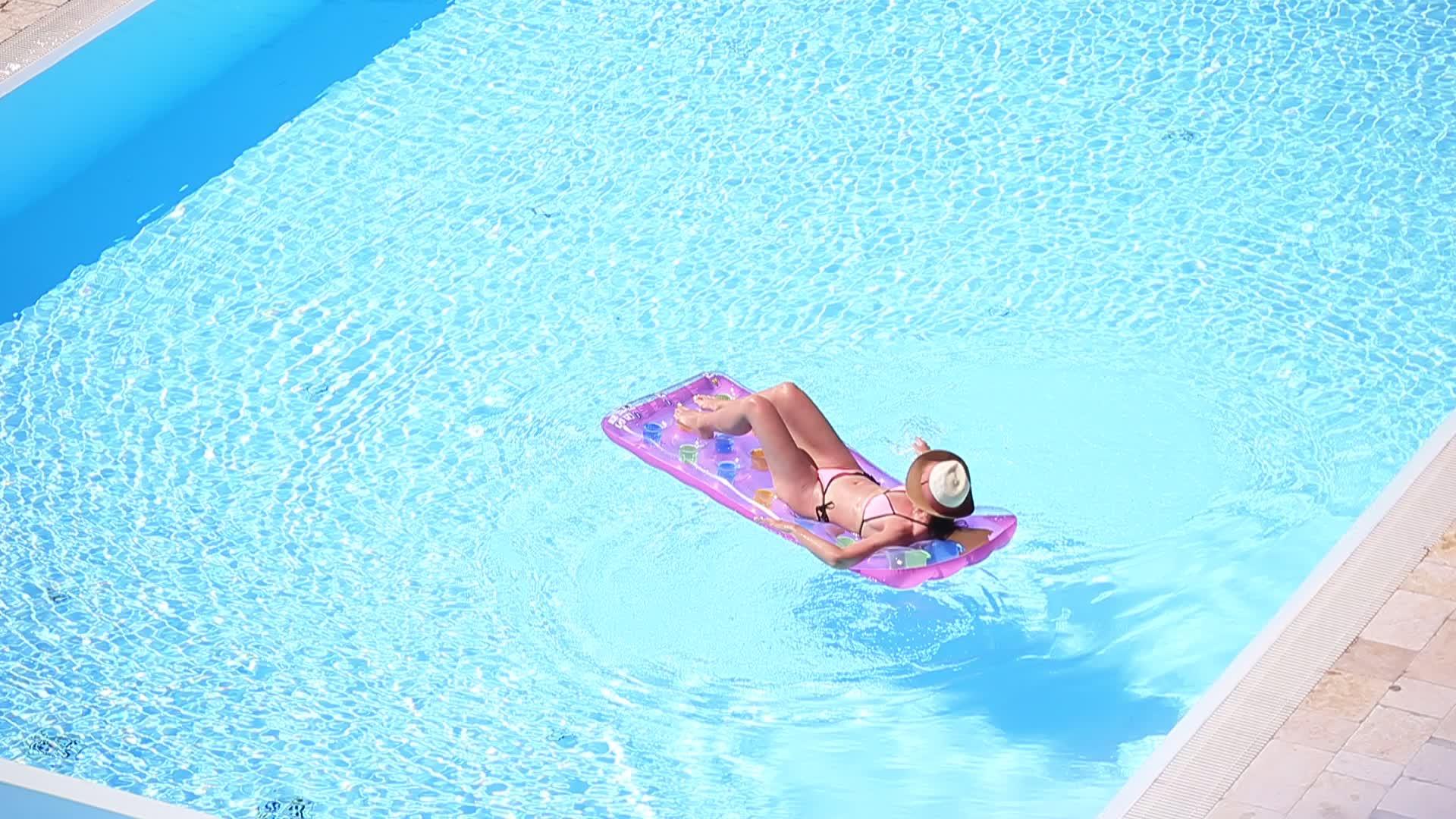 美丽的年轻女子在游泳池里放松视频的预览图