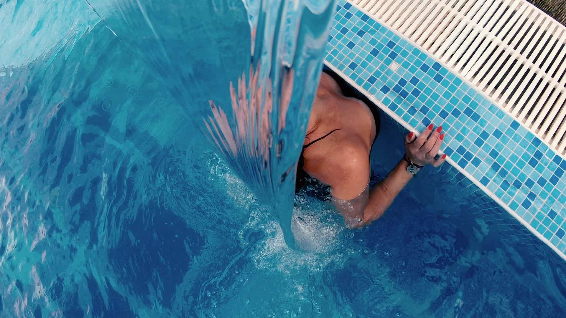 在喷气式飞机下的游泳池里穿着比基尼的性感女性可以享受视频的预览图