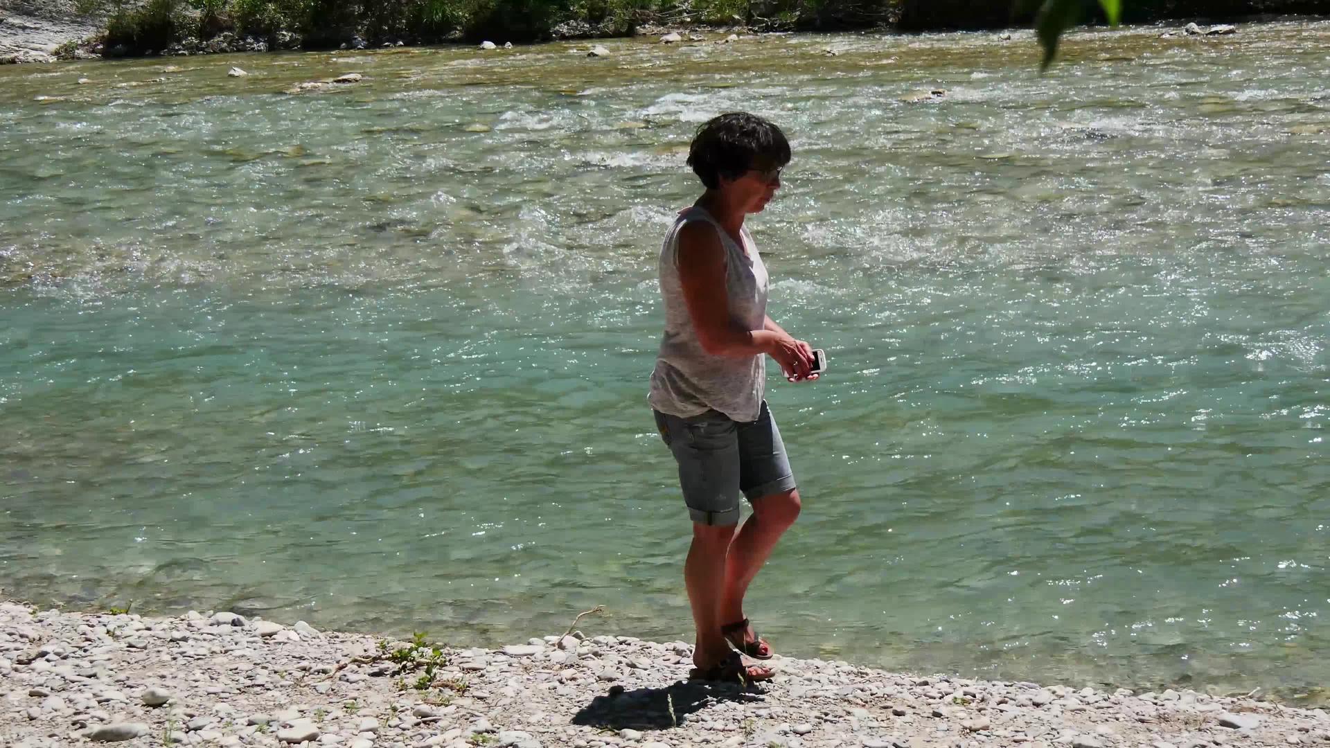 沿河行走的妇女视频的预览图