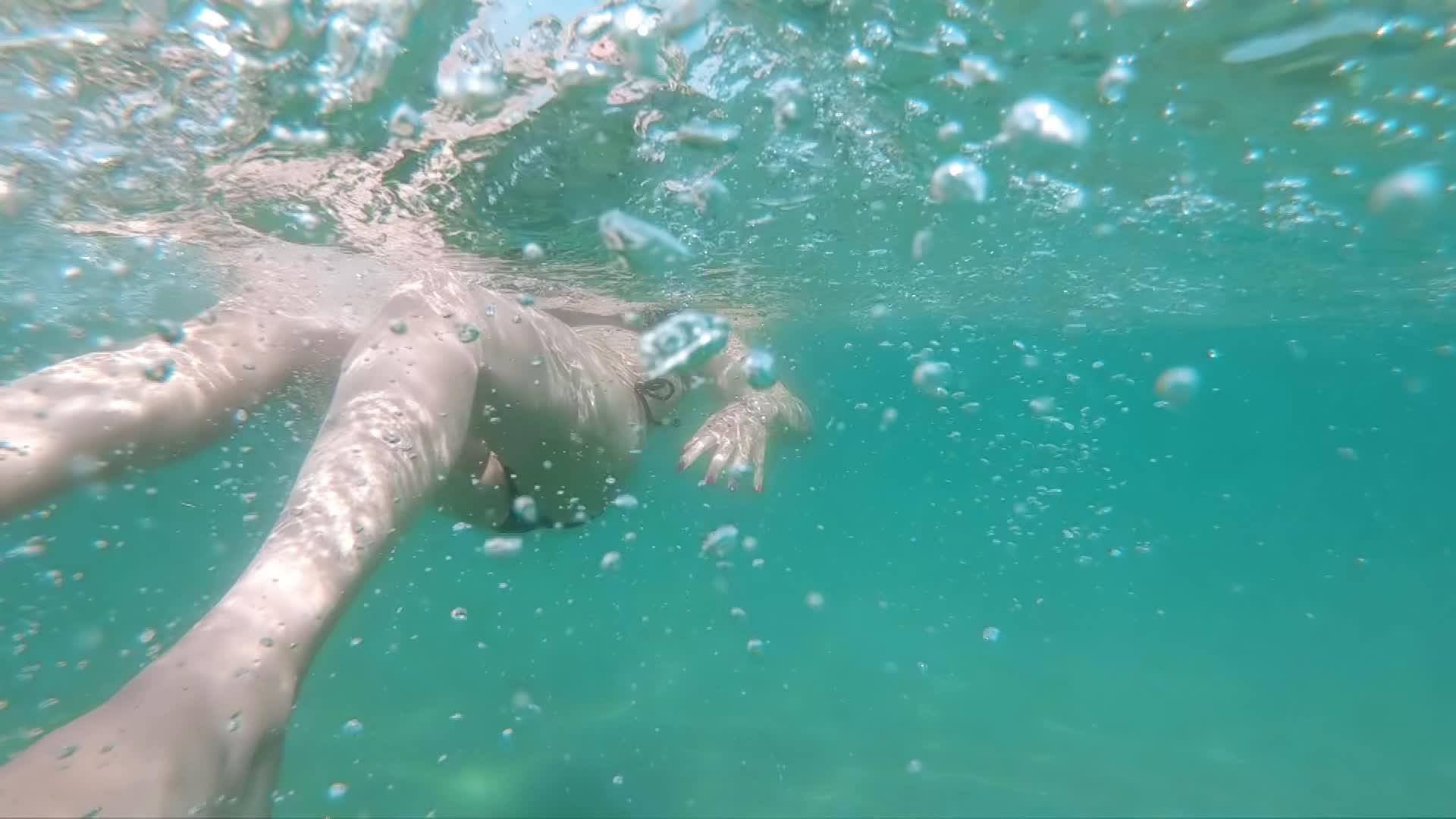 女性在海里向后游在水下慢慢拍摄视频的预览图