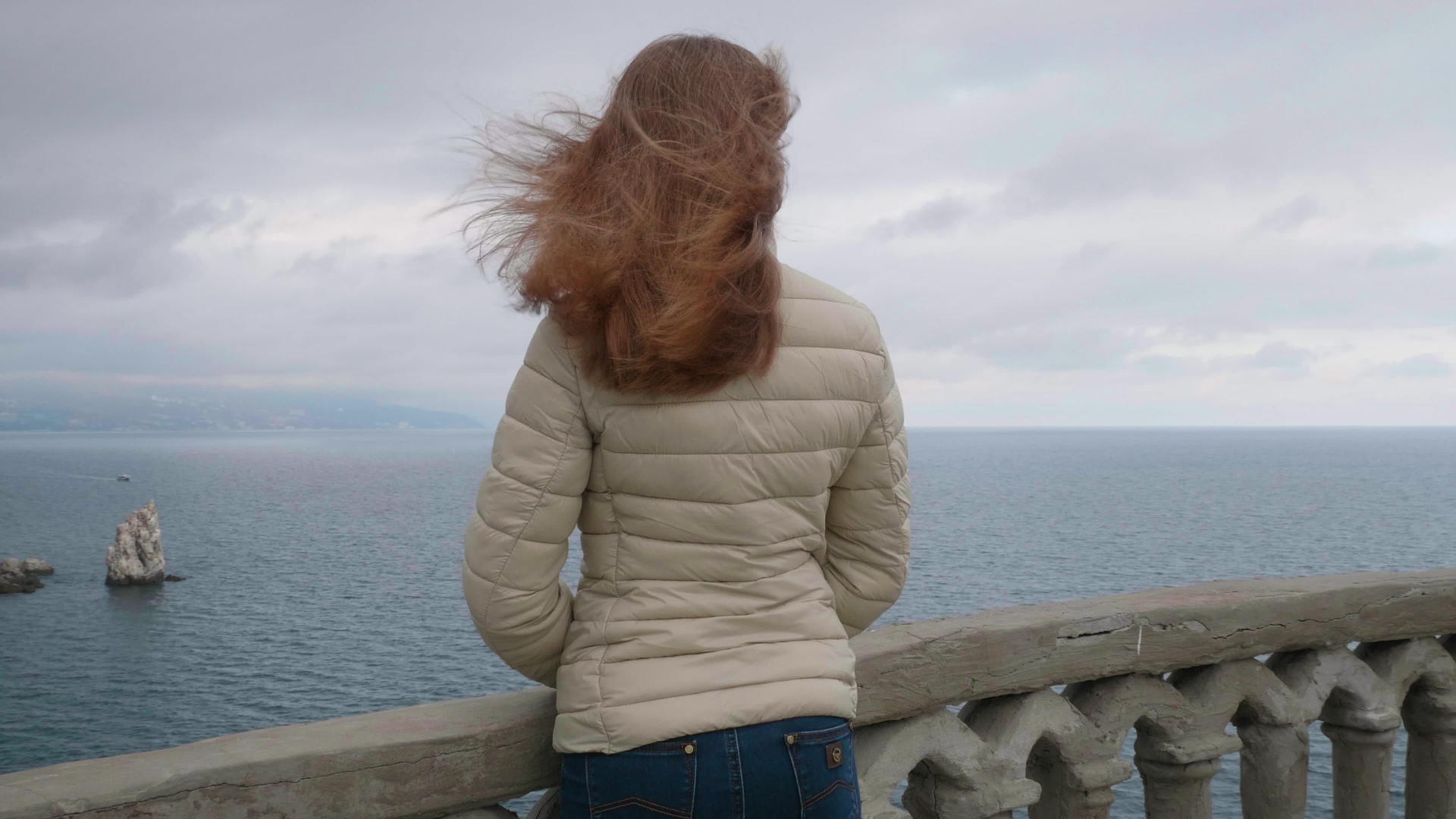 年轻苗条的女人留着棕色的长发站在阳台上视频的预览图