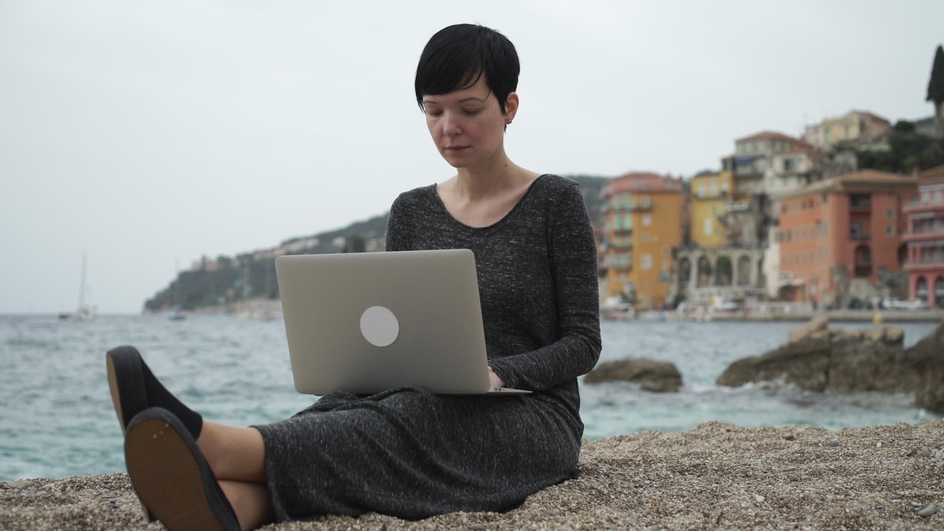 妇女在海边的计算机上工作视频的预览图