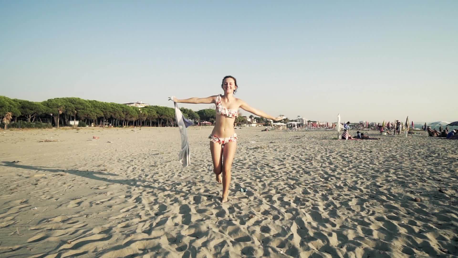 美丽的女孩带着白色围巾在海滩上旅行假期自由概念慢动作...视频的预览图