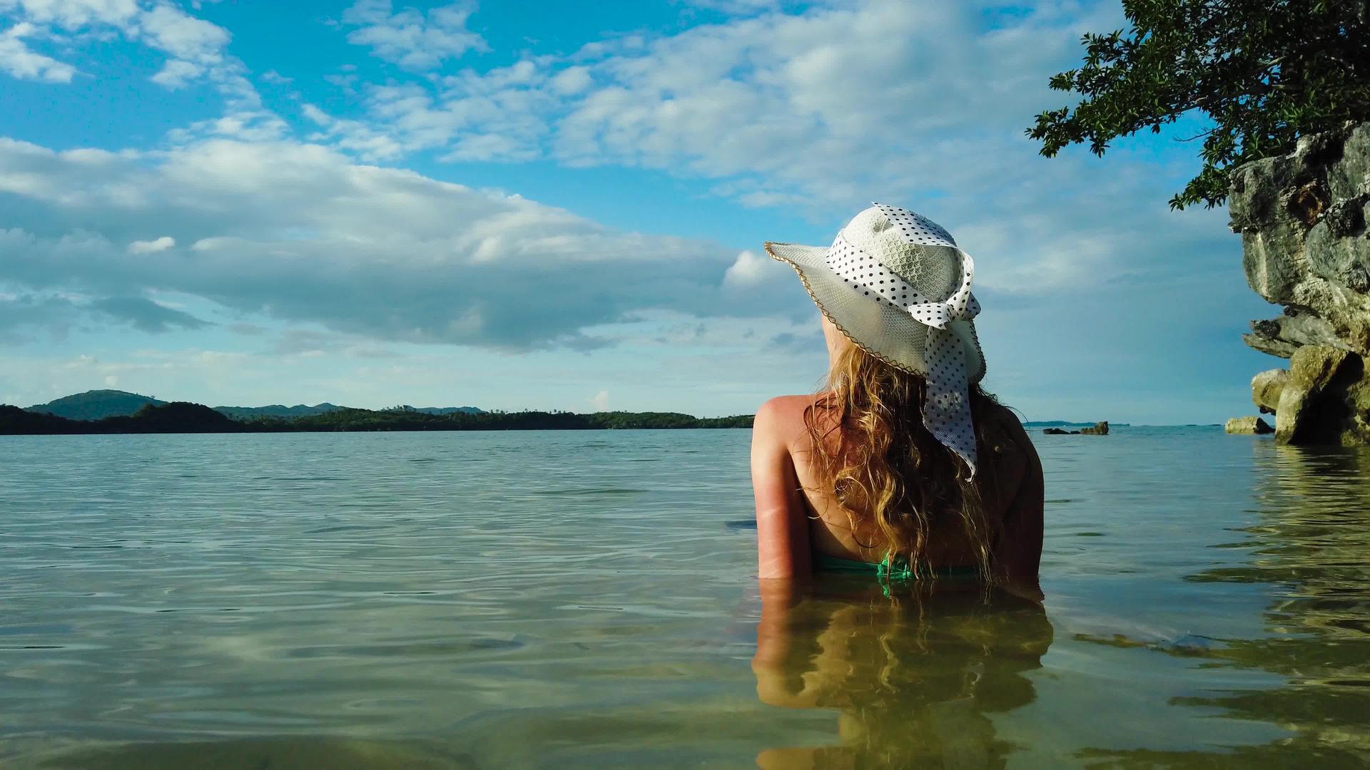 在海滩上戴帽子的女人视频的预览图