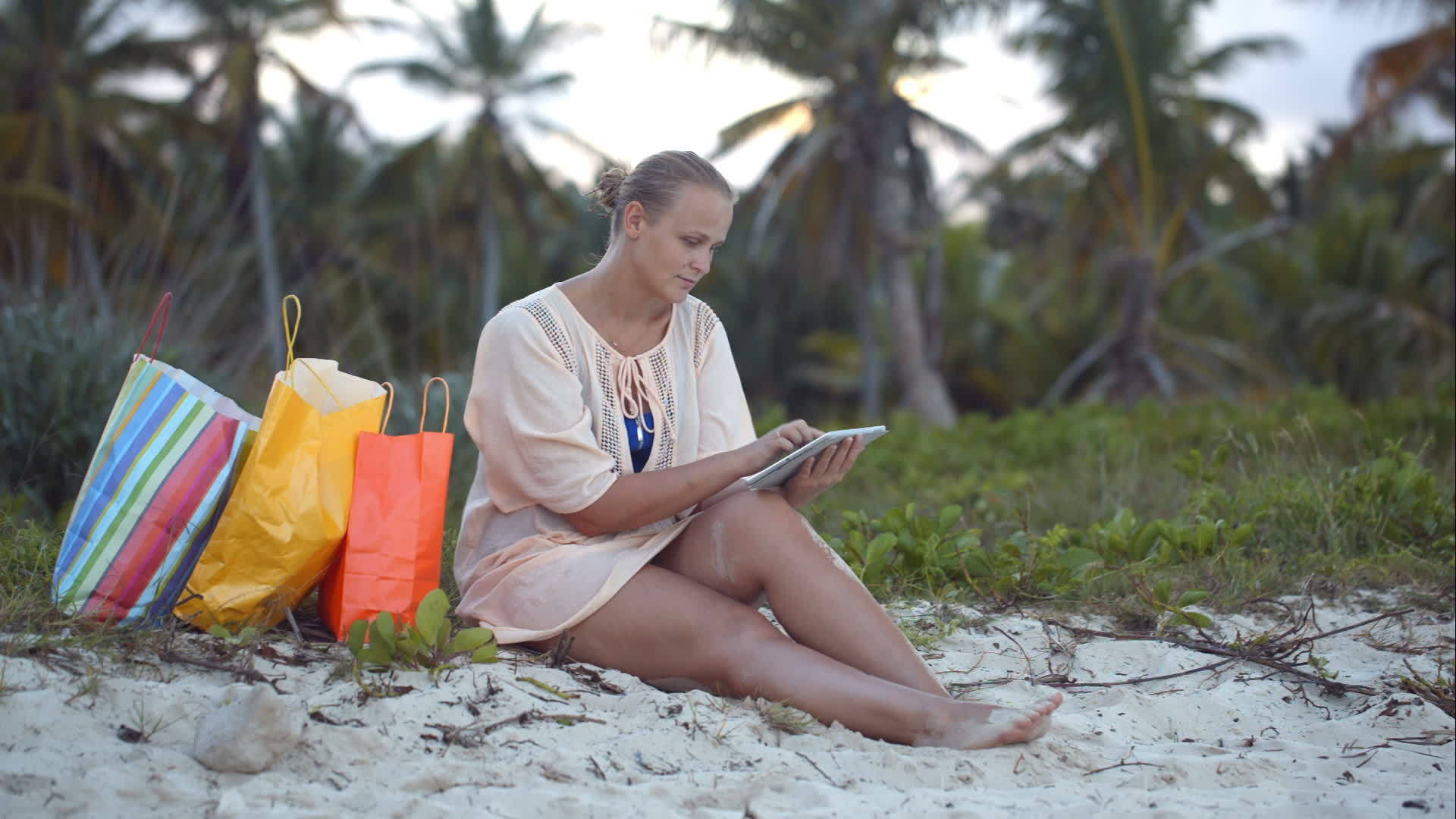 购物后女性在海滩上购买平板电脑视频的预览图