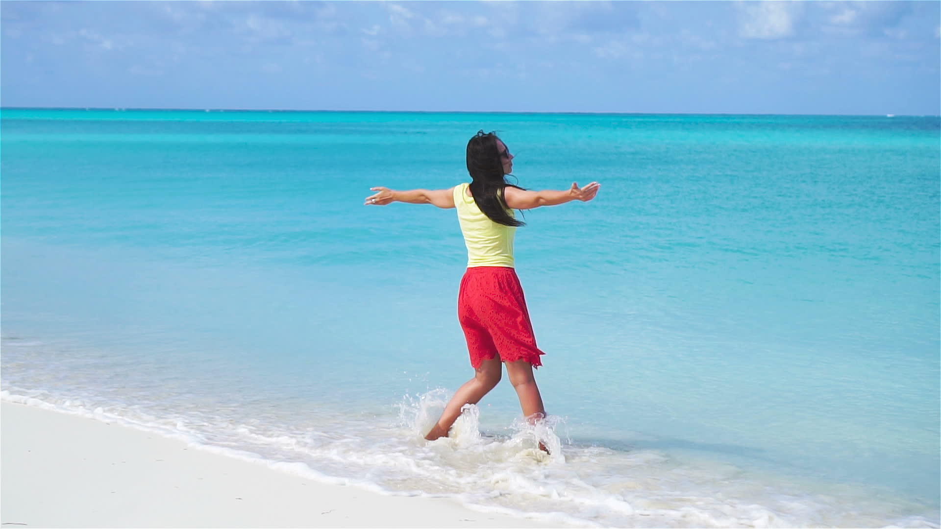 海滩上年轻美女在浅水中散步的慢动作视频很慢视频的预览图
