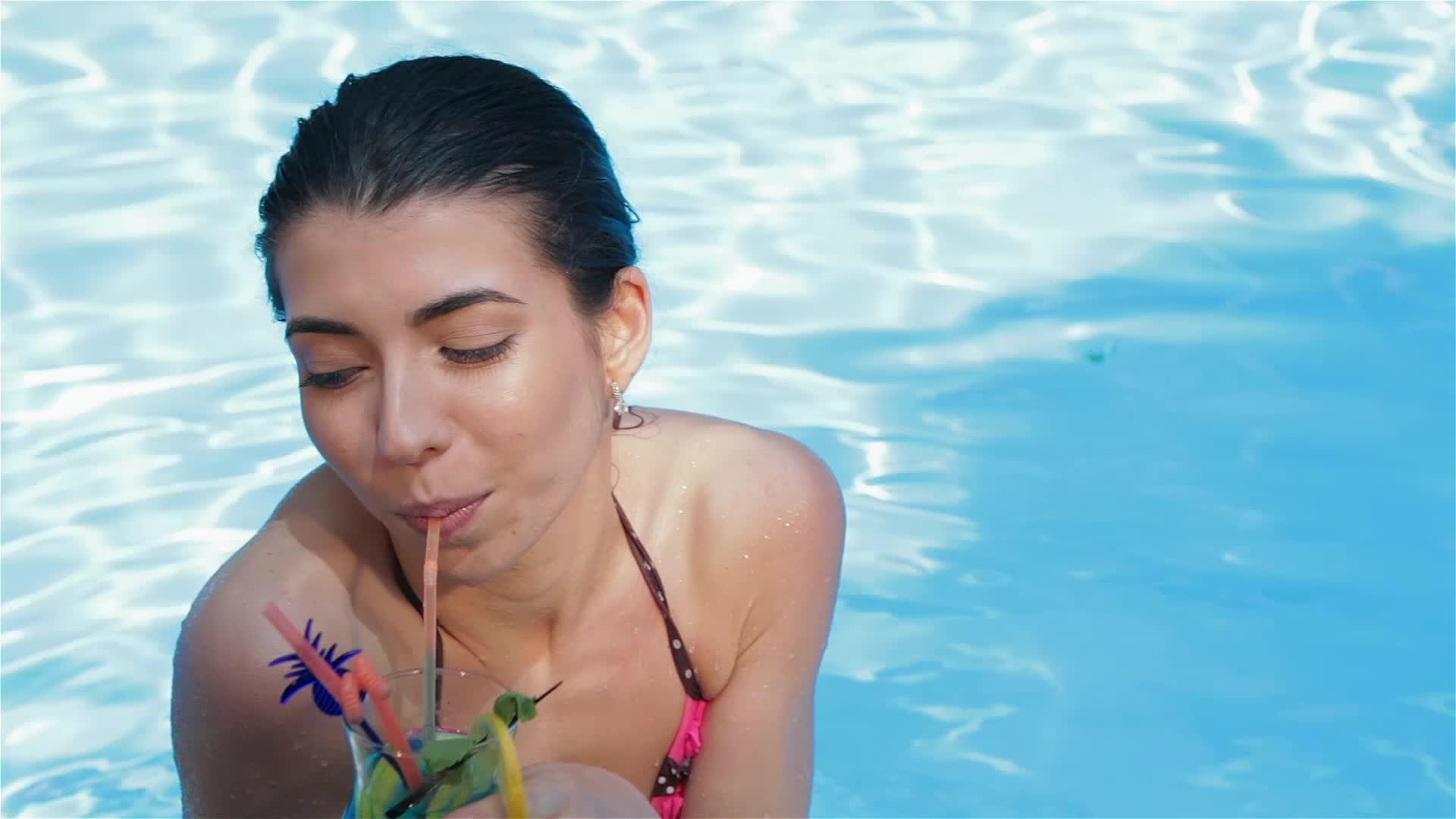 女人从游泳池里喝了一杯鸡尾酒视频的预览图