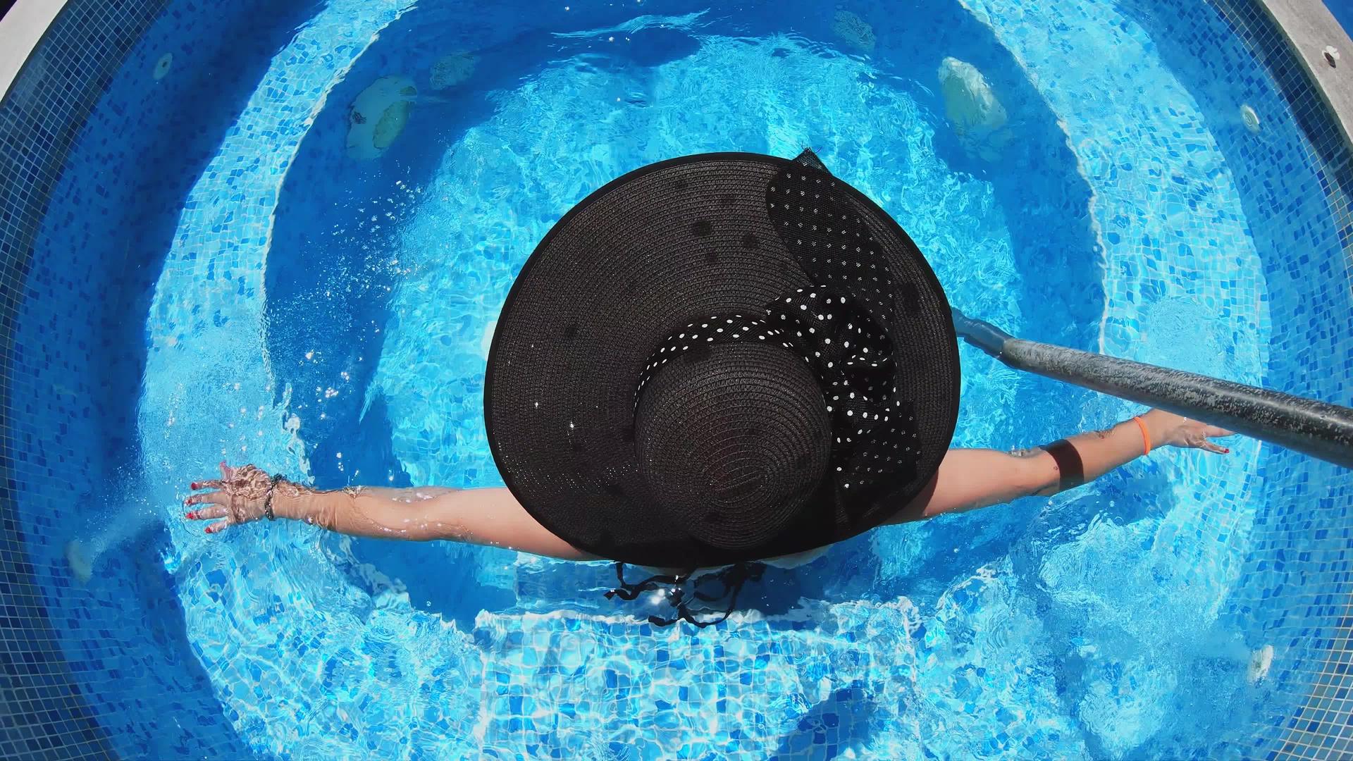 快乐的黑帽女人在游泳池温泉里放松视频的预览图
