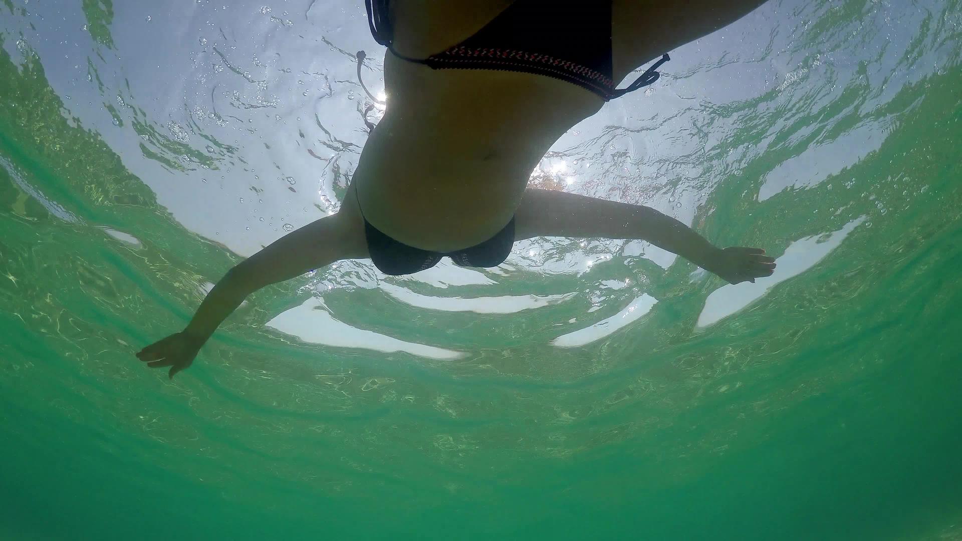一个年轻的女人在宁静的海水上游泳夏天阳光明媚视频的预览图