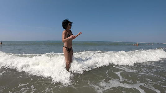 女人在狂浪中漫步享受暑假视频的预览图