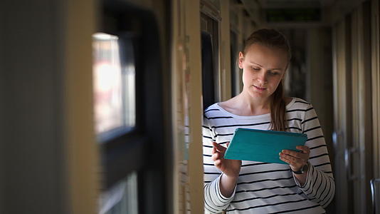 年轻女子站在火车走廊的窗户旁有垫子视频的预览图