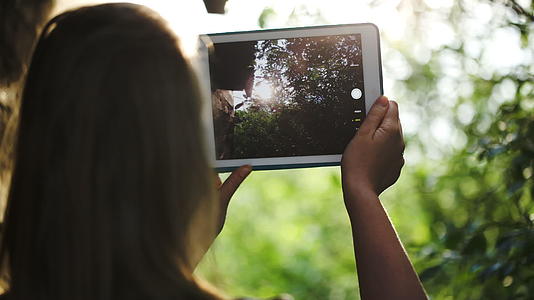 用平板电脑拍摄自然照片的女性视频的预览图