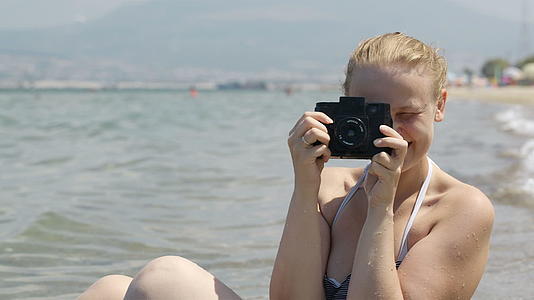 这位微笑的女士和她的旧相机在海边拍照视频的预览图