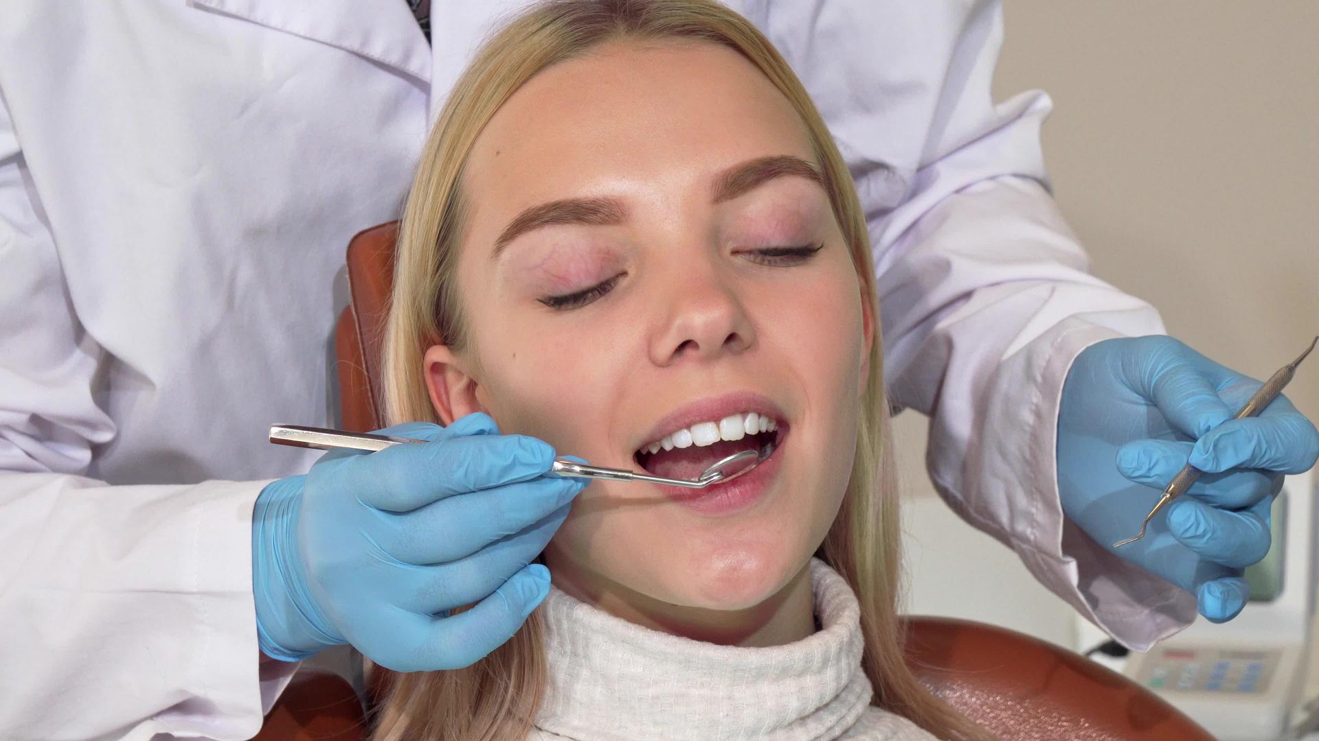 在接受牙医检查牙齿后快乐的女人对着相机微笑视频的预览图