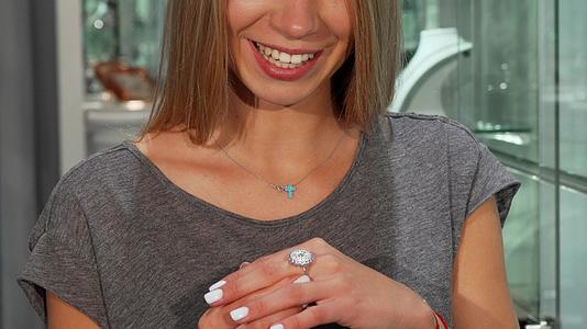 快乐的女士微笑着尝试在珠宝商出售钻石戒指视频的预览图