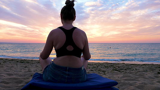 女人们在海边做瑜伽在日出的海滩上观看全景的全景视频的预览图