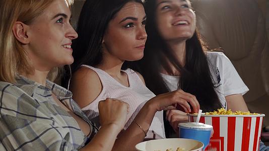 三个年轻的女性朋友一起看电影笑着笑着视频的预览图