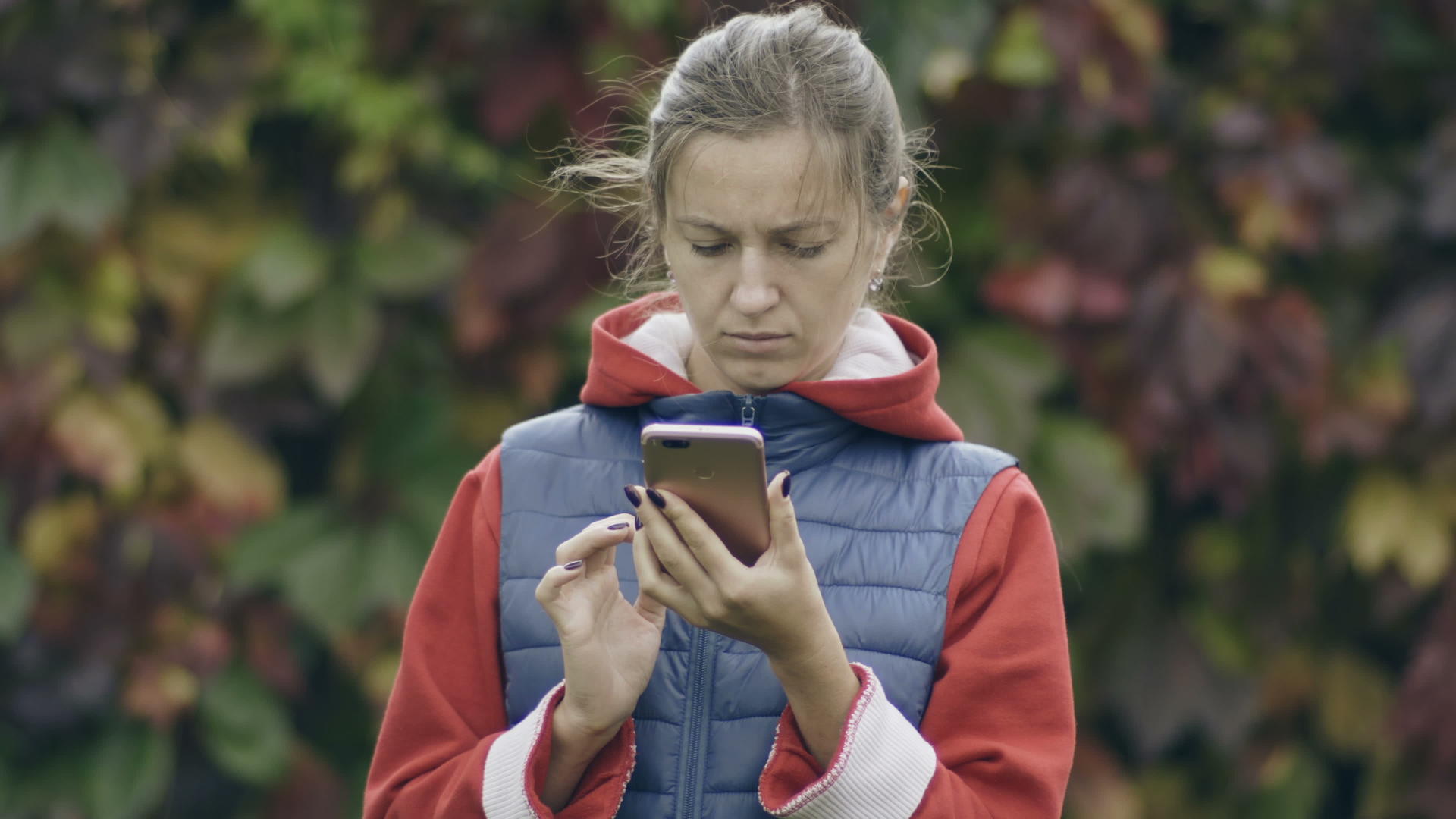 年轻女性在外面使用手机的情况视频的预览图