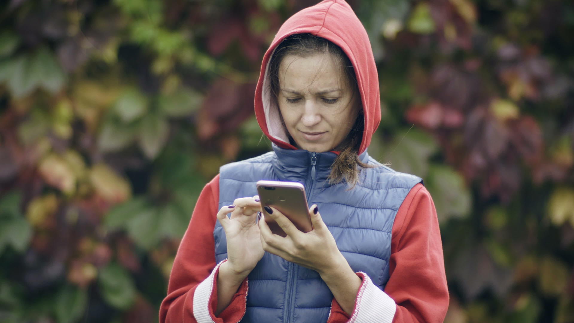 年轻女性在外面使用手机视频的预览图