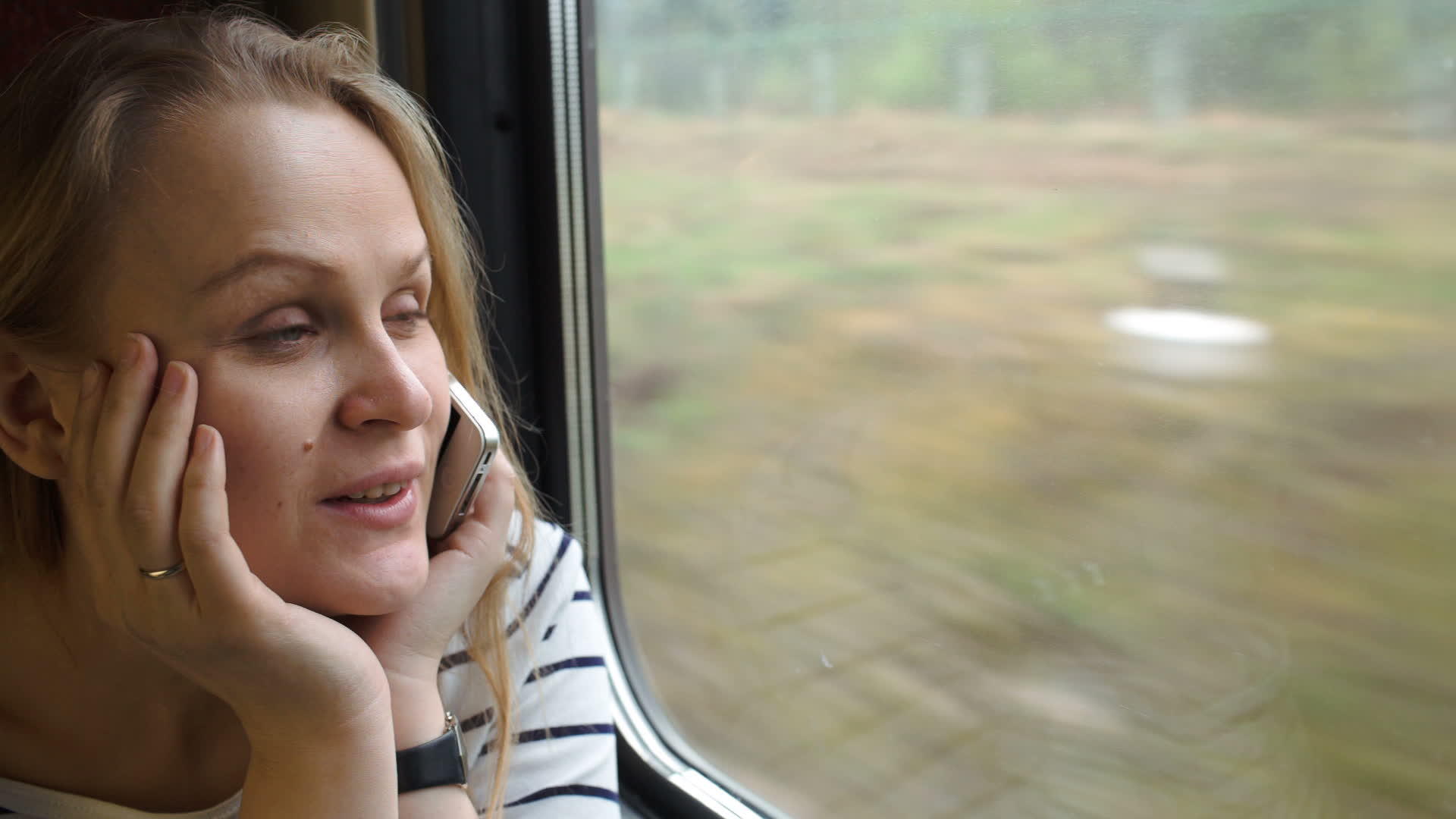 坐火车旅行时年轻女性通过电话交谈；和；视频的预览图